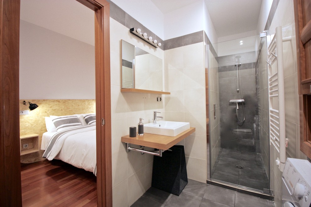Ejemplo de cuarto de baño escandinavo de tamaño medio con lavabo sobreencimera, encimera de madera, ducha con puerta con bisagras, ducha empotrada, baldosas y/o azulejos grises, aseo y ducha, suelo gris y espejo con luz