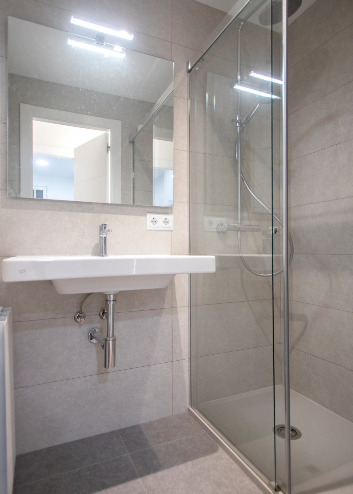 Modern inredning av ett mellanstort vit vitt en-suite badrum, med en kantlös dusch, en toalettstol med hel cisternkåpa, vit kakel, keramikplattor, vita väggar och dusch med gångjärnsdörr