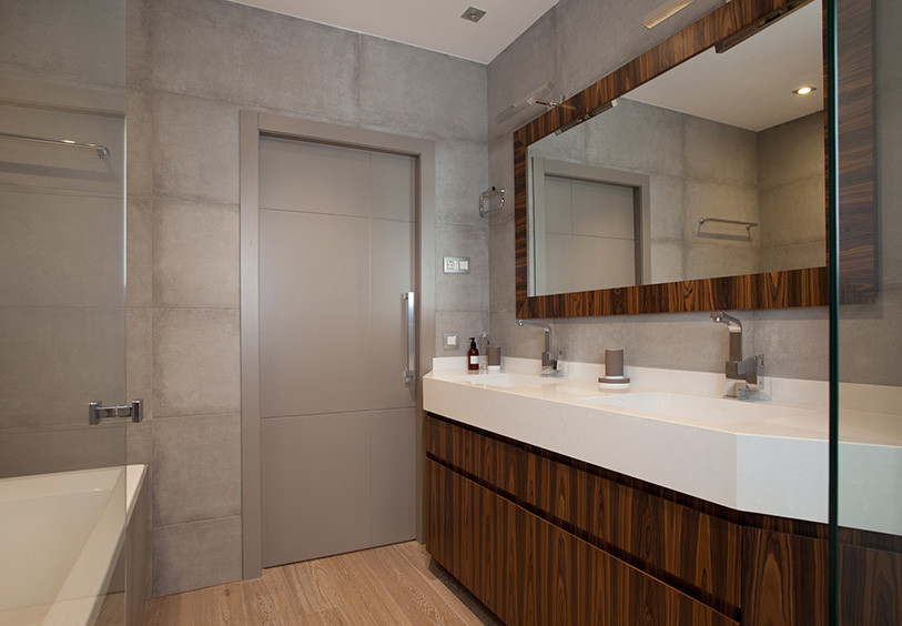 Idee per una stanza da bagno padronale classica di medie dimensioni con ante lisce, ante in legno scuro, vasca ad alcova, vasca/doccia, pareti grigie e lavabo integrato