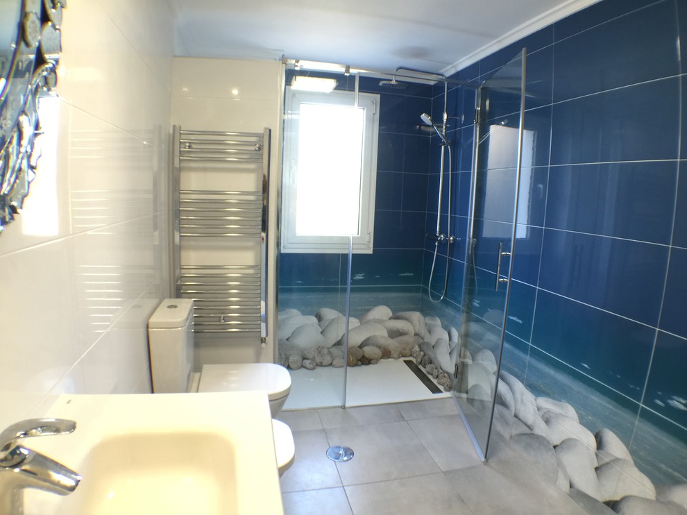 Inredning av ett maritimt mellanstort badrum med dusch, med en kantlös dusch, en toalettstol med separat cisternkåpa, flerfärgade väggar, klinkergolv i keramik och ett integrerad handfat