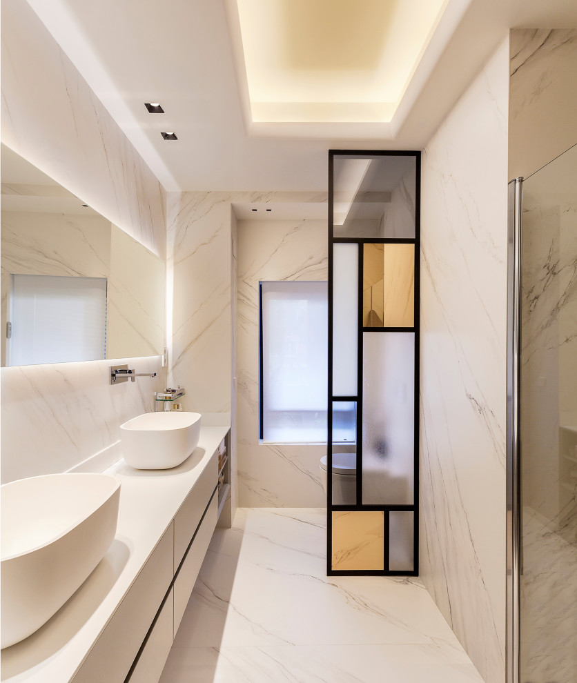 マドリードにあるコンテンポラリースタイルのおしゃれな浴室 (フラットパネル扉のキャビネット、白いキャビネット、ベッセル式洗面器、白い床、白い洗面カウンター) の写真