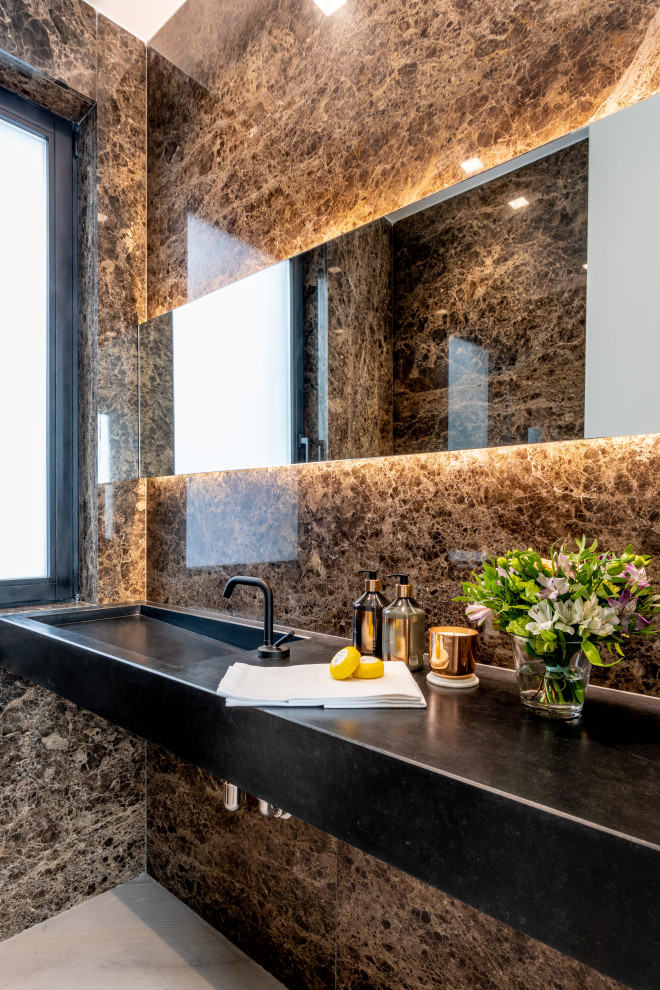 На фото: большая ванная комната в современном стиле с черными фасадами, коричневой плиткой, монолитной раковиной, серым полом, черной столешницей, тумбой под одну раковину и подвесной тумбой