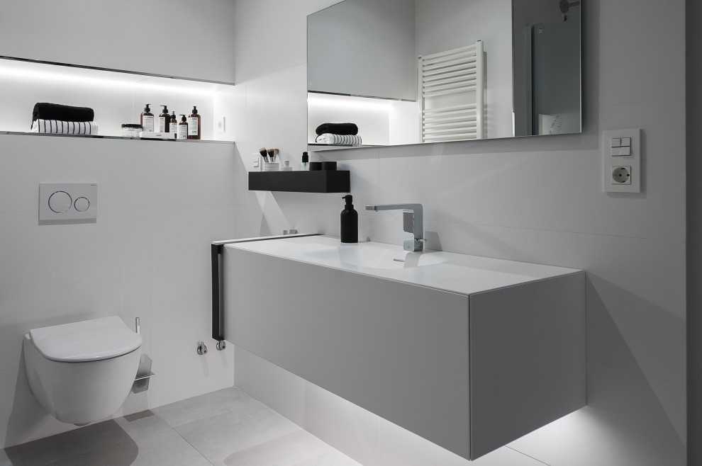 Example of a transitional white tile and ceramic tile porcelain tile, gray floor and single-sink bathroom design in Other with recessed-panel cabinets, white cabinets, a wall-mount sink, white countertops and a floating vanity