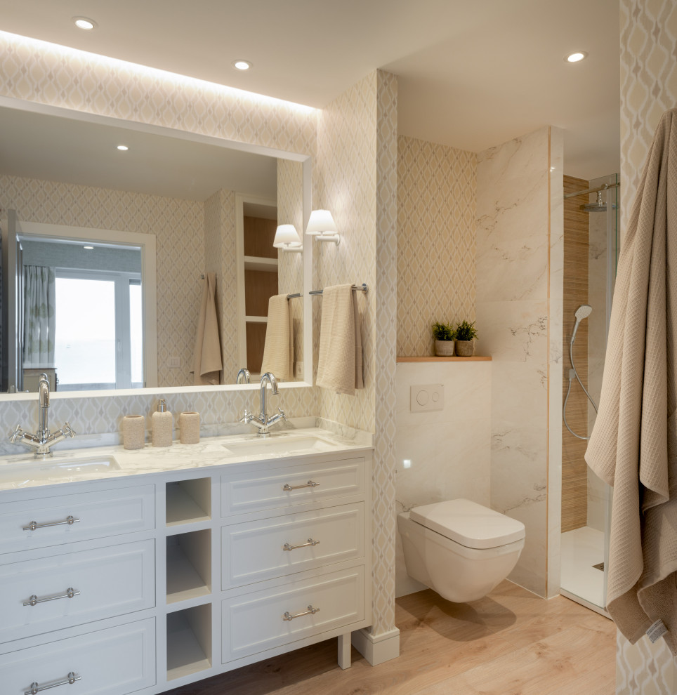 Exempel på ett stort klassiskt vit vitt en-suite badrum, med vita skåp, en dusch i en alkov, en vägghängd toalettstol, beige kakel, porslinskakel, beige väggar, laminatgolv, ett undermonterad handfat, bänkskiva i kvarts, brunt golv, dusch med gångjärnsdörr och luckor med infälld panel