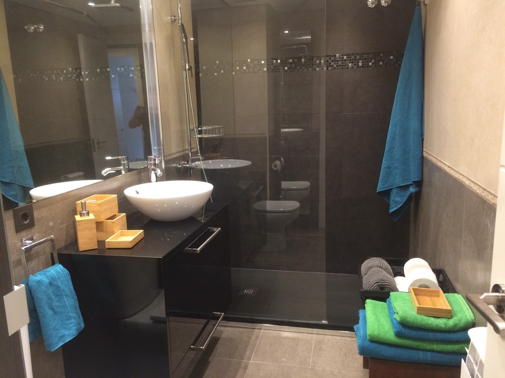 Exempel på ett litet modernt svart svart en-suite badrum, med släta luckor, svarta skåp, våtrum, ett urinoar, flerfärgad kakel, porslinskakel, flerfärgade väggar, klinkergolv i porslin, ett fristående handfat, träbänkskiva och beiget golv