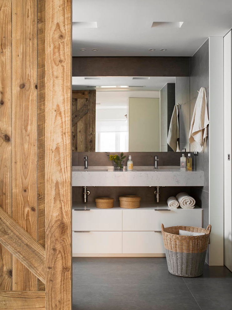 Immagine di una stanza da bagno stile rurale di medie dimensioni con ante lisce, ante bianche, pareti grigie e lavabo integrato