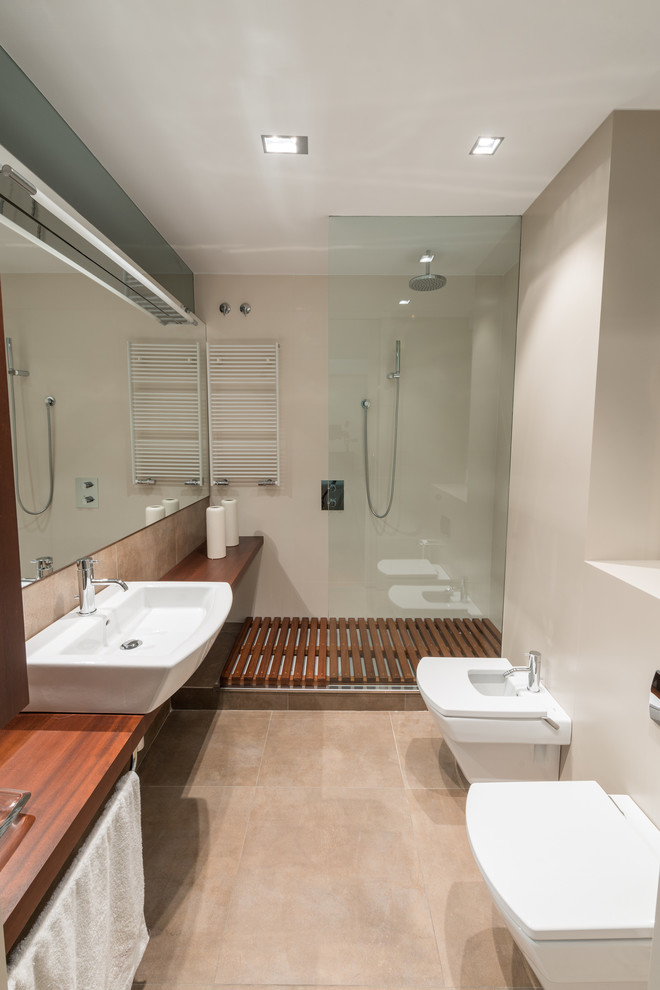 Ejemplo de cuarto de baño principal escandinavo de tamaño medio con ducha abierta, bidé, paredes beige, suelo de baldosas de cerámica, lavabo sobreencimera y encimera de madera
