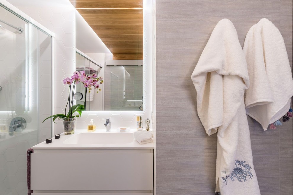 マラガにある低価格の中くらいな北欧スタイルのおしゃれなマスターバスルーム (バリアフリー、白いタイル、セラミックタイル、白い壁、セラミックタイルの床、オーバーカウンターシンク、グレーの床、引戸のシャワー) の写真