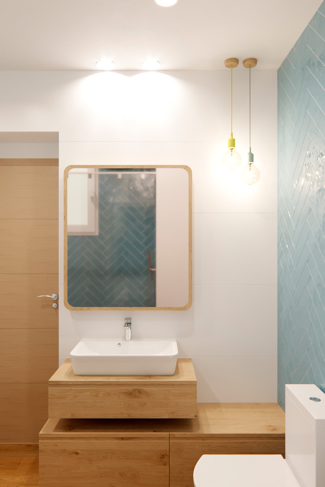 Пример оригинального дизайна: маленькая главная ванная комната в скандинавском стиле с фасадами островного типа, светлыми деревянными фасадами, накладной ванной, синей плиткой, керамической плиткой, белыми стенами, столешницей из дерева и душем с раздвижными дверями для на участке и в саду