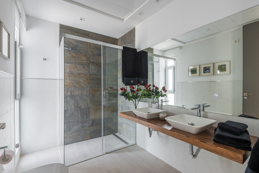 Foto di una stanza da bagno con doccia design di medie dimensioni con doccia ad angolo, pareti multicolore, lavabo a bacinella e top in legno