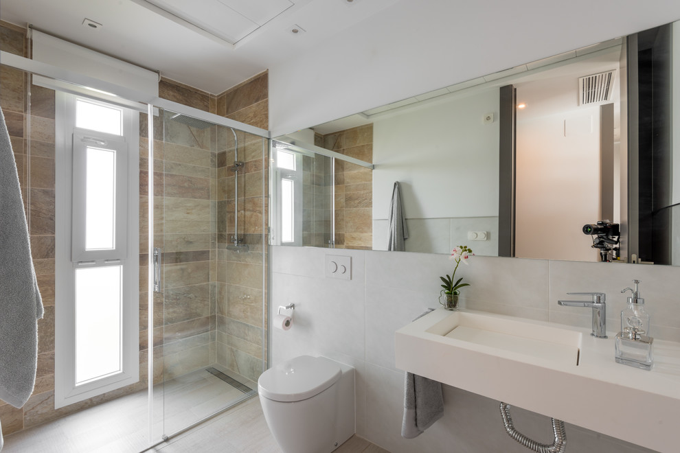 Foto di una stanza da bagno con doccia minimal di medie dimensioni con doccia a filo pavimento, WC monopezzo, pareti multicolore e lavabo integrato