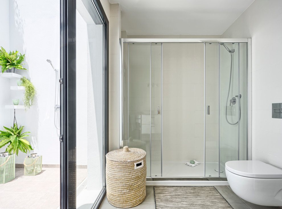 Ejemplo de cuarto de baño marinero grande con ducha doble, sanitario de pared, paredes blancas y suelo de baldosas de porcelana