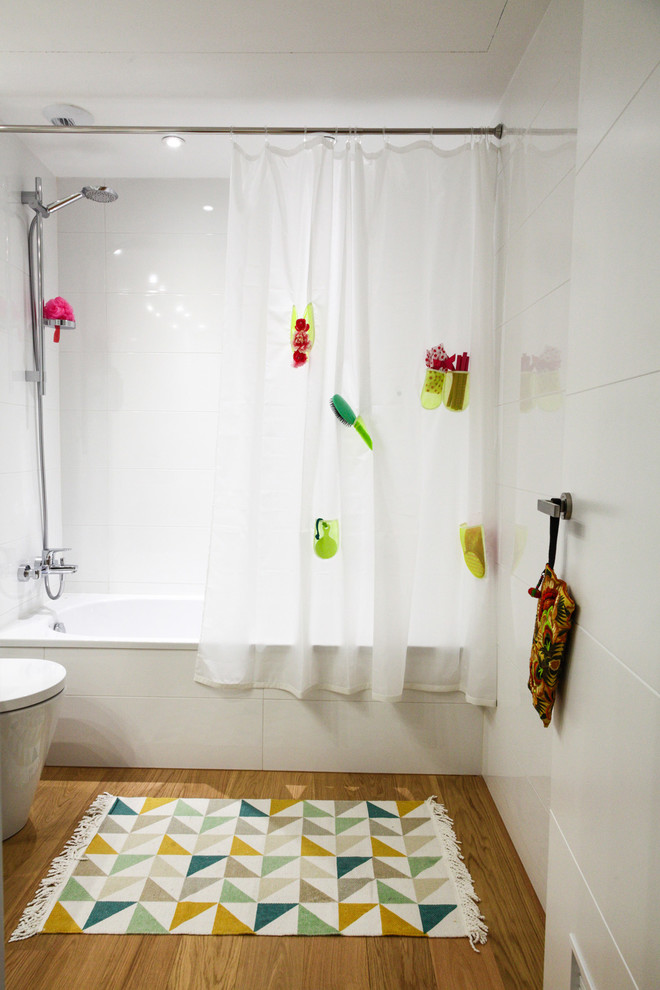 Inredning av ett minimalistiskt mellanstort badrum för barn, med ett platsbyggt badkar, vita väggar, mellanmörkt trägolv och en dusch/badkar-kombination