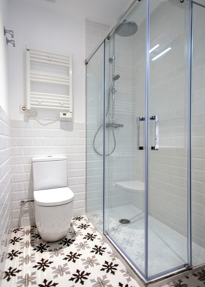 Exempel på ett stort modernt vit vitt en-suite badrum, med vita skåp, en kantlös dusch, en toalettstol med hel cisternkåpa, vit kakel, porslinskakel, vita väggar och dusch med skjutdörr