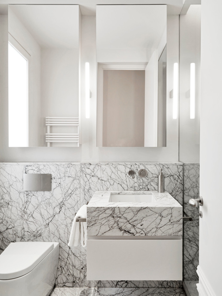 Idéer för ett litet modernt badrum, med släta luckor, vita skåp, en vägghängd toalettstol, vita väggar, ett undermonterad handfat, grå kakel, marmorkakel, marmorgolv, marmorbänkskiva och grått golv