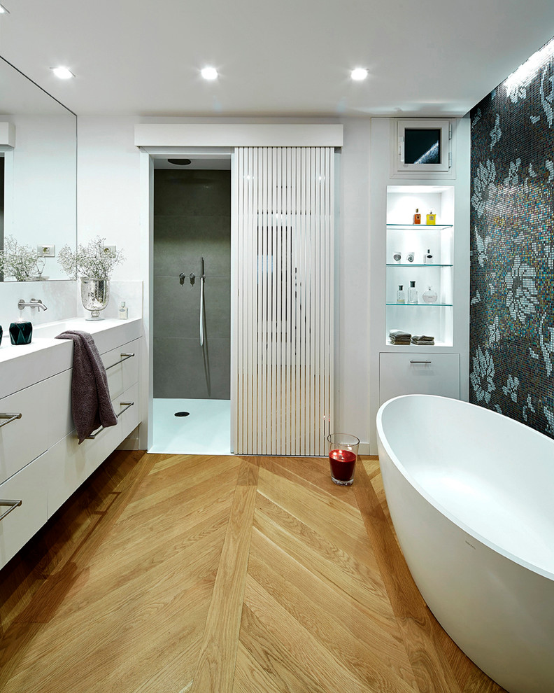 Inspiration pour une salle de bain principale traditionnelle de taille moyenne avec un placard à porte plane, des portes de placard blanches, une baignoire indépendante, un combiné douche/baignoire, un mur blanc, un sol en bois brun et un lavabo intégré.