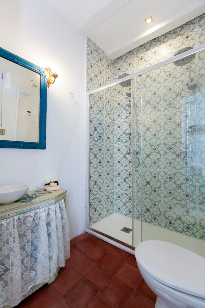 Réalisation d'une salle de bain bohème de taille moyenne avec un placard sans porte, WC séparés, un mur multicolore, tomettes au sol et une vasque.