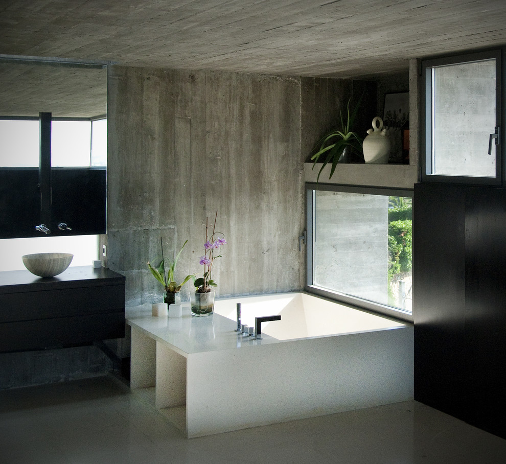Exempel på ett stort modernt en-suite badrum, med släta luckor, skåp i mörkt trä, en jacuzzi, grå kakel, cementkakel, bänkskiva i kvartsit, en hörndusch, en toalettstol med hel cisternkåpa, ett fristående handfat, grå väggar och klinkergolv i porslin