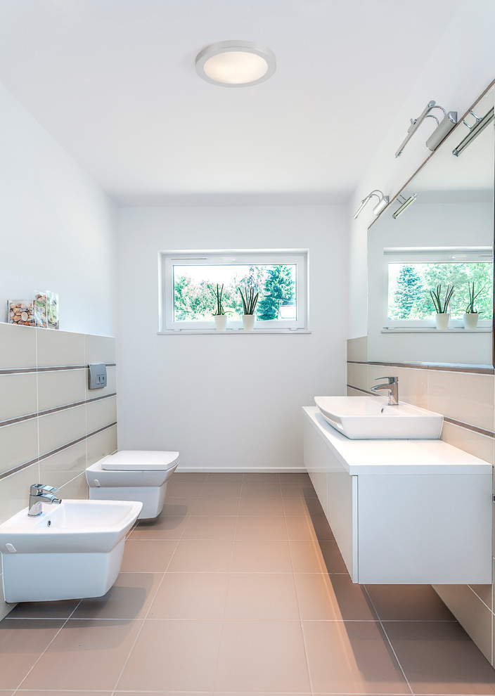 Foto på ett stort funkis badrum, med släta luckor, vita skåp, en bidé, vita väggar, klinkergolv i keramik och ett fristående handfat