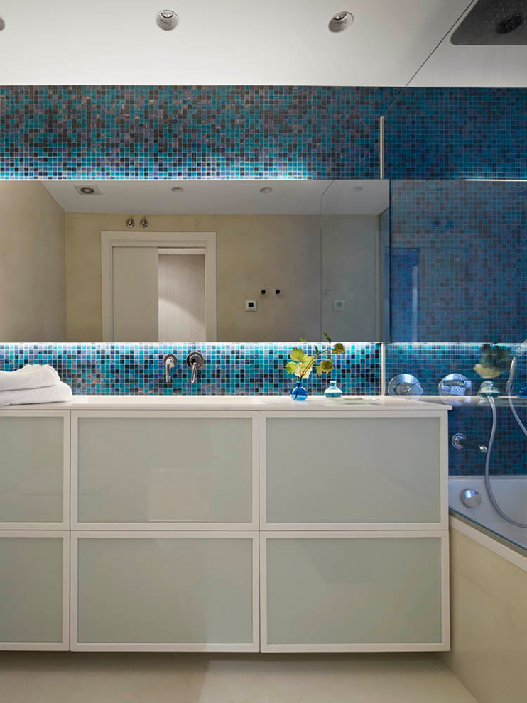 Imagen de cuarto de baño principal de tamaño medio con bañera encastrada, baldosas y/o azulejos azules, paredes beige, suelo de madera en tonos medios, lavabo bajoencimera y suelo marrón