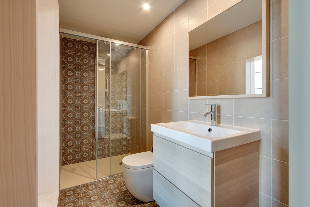 Идея дизайна: ванная комната среднего размера в средиземноморском стиле с плоскими фасадами, светлыми деревянными фасадами, душем в нише, унитазом-моноблоком, бежевой плиткой, керамической плиткой, бежевыми стенами, душевой кабиной и монолитной раковиной