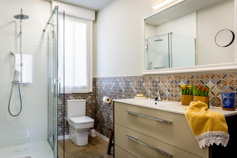 Источник вдохновения для домашнего уюта: маленькая ванная комната в современном стиле с плоскими фасадами, бежевыми фасадами, угловым душем, раздельным унитазом, белыми стенами, душевой кабиной, монолитной раковиной, душем с распашными дверями, белой столешницей, синей плиткой, коричневой плиткой и коричневым полом для на участке и в саду