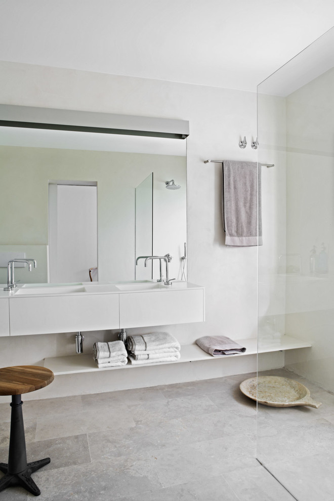 Diseño de cuarto de baño principal actual con ducha abierta, baldosas y/o azulejos de piedra, paredes blancas y lavabo suspendido