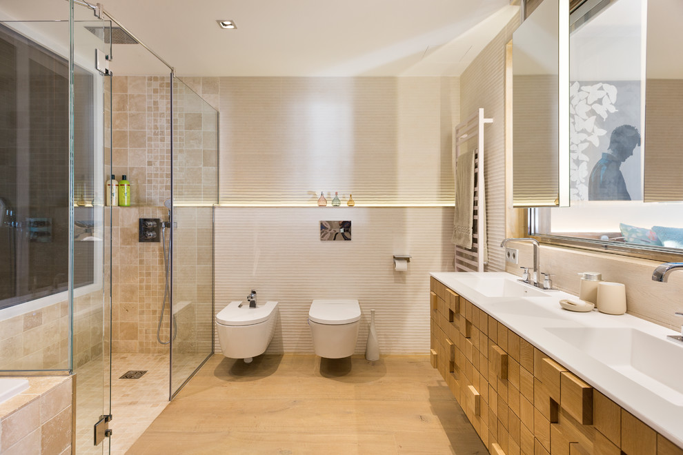 Bild på ett mycket stort funkis en-suite badrum, med en jacuzzi, en kantlös dusch, en bidé, beige kakel, porslinskakel, beige väggar, ljust trägolv, ett integrerad handfat, bänkskiva i onyx, beiget golv och dusch med gångjärnsdörr