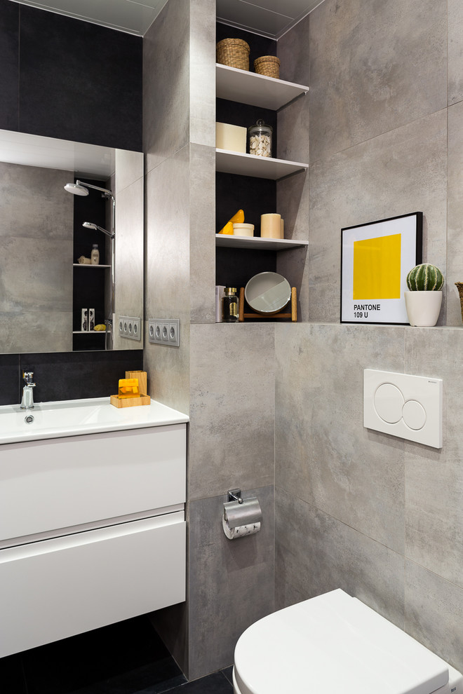 Esempio di una stanza da bagno con doccia contemporanea con ante lisce, ante bianche, WC sospeso, piastrelle grigie, lavabo integrato e pavimento nero