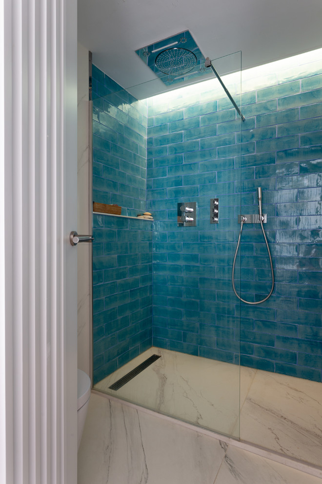 Réalisation d'une salle de bain principale nordique de taille moyenne avec des portes de placard blanches, WC suspendus, un mur blanc, un sol en carrelage de céramique, une vasque, un plan de toilette en carrelage, un sol blanc, une douche à l'italienne, un carrelage bleu, des carreaux de céramique et un plan de toilette marron.