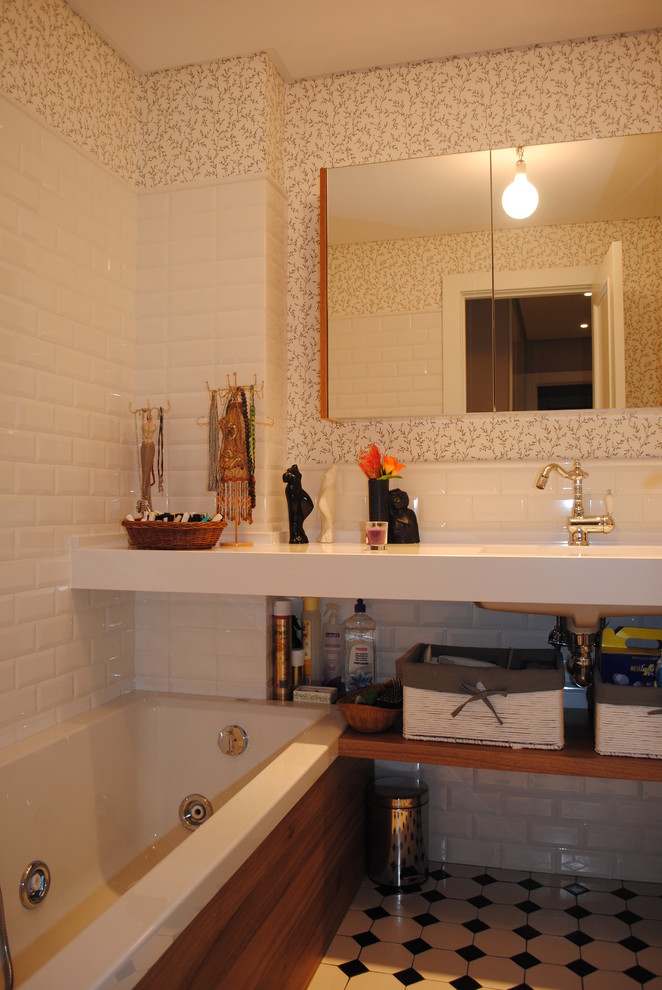 Foto de cuarto de baño principal urbano de tamaño medio con armarios abiertos, puertas de armario de madera oscura, bañera empotrada, combinación de ducha y bañera, paredes multicolor y lavabo integrado