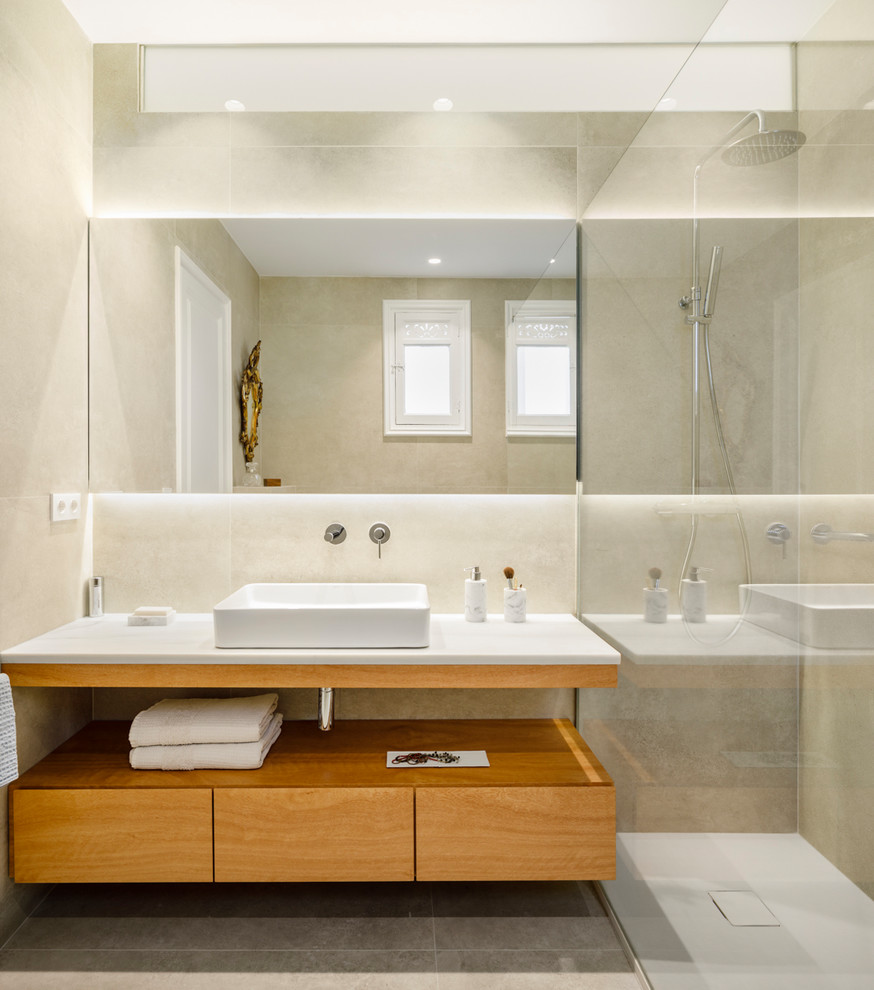 Exemple d'une salle d'eau tendance en bois brun avec une douche ouverte, un carrelage beige, des carreaux de porcelaine, un mur beige, un sol en carrelage de porcelaine, un sol gris, aucune cabine, un plan de toilette blanc, un placard à porte plane et une vasque.