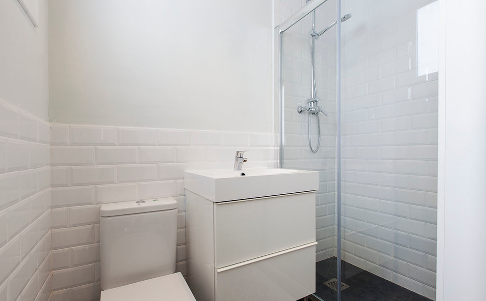 Ispirazione per una stanza da bagno con doccia nordica di medie dimensioni con ante lisce, ante bianche, doccia a filo pavimento, WC a due pezzi, pareti bianche e lavabo integrato
