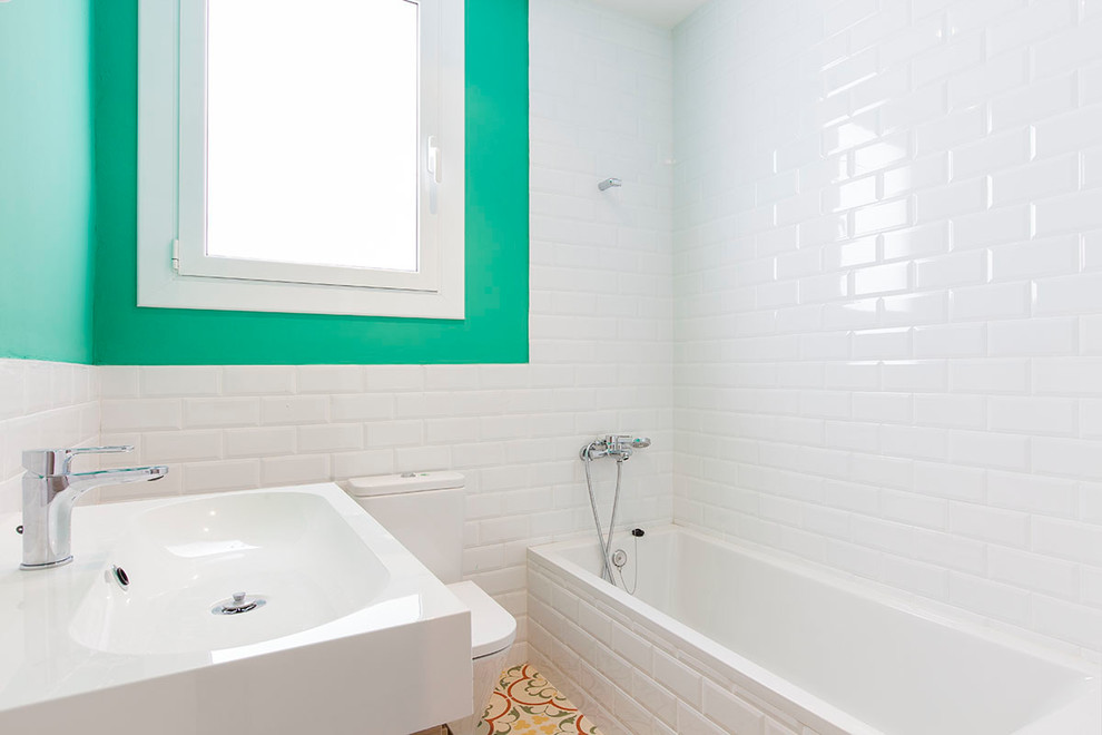Mittelgroßes Skandinavisches Badezimmer En Suite mit Badewanne in Nische, Duschbadewanne, Wandtoilette mit Spülkasten, weißer Wandfarbe und integriertem Waschbecken in Barcelona