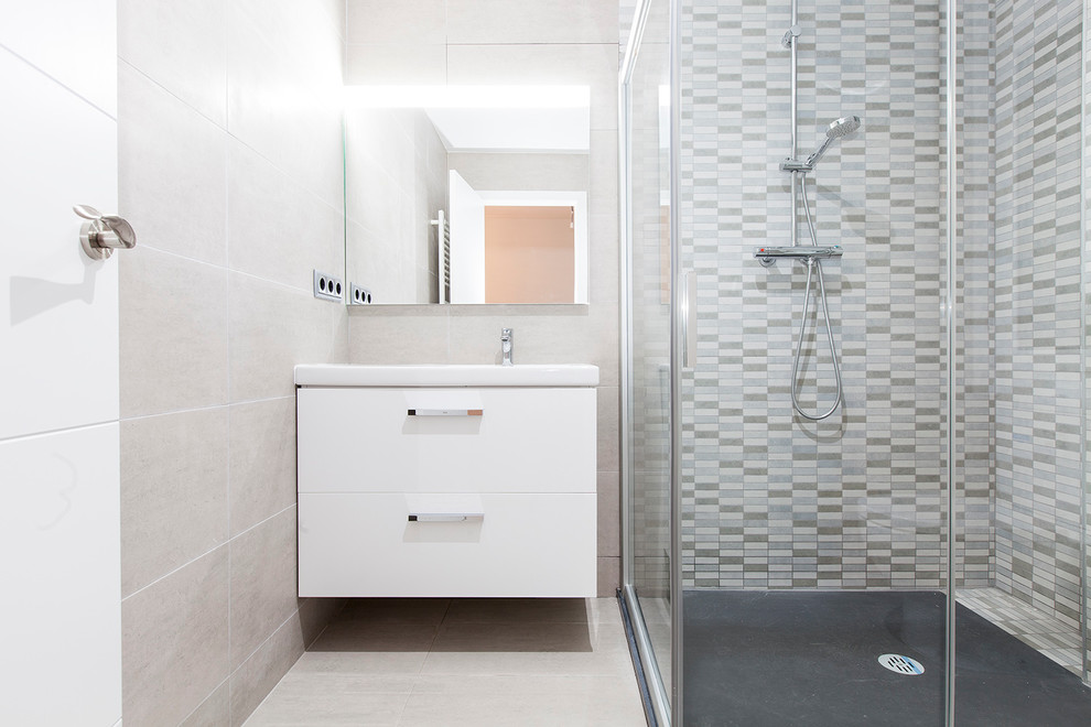 Immagine di una stanza da bagno con doccia tradizionale di medie dimensioni con ante lisce, ante bianche, doccia ad angolo, pareti multicolore, pavimento con piastrelle in ceramica e lavabo integrato