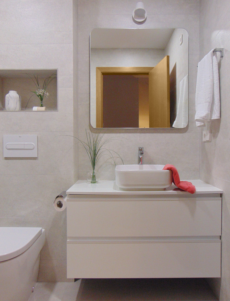 Пример оригинального дизайна: ванная комната среднего размера в современном стиле с белыми фасадами, душем без бортиков, инсталляцией, серой плиткой, керамогранитной плиткой, серыми стенами, полом из керамогранита, душевой кабиной, настольной раковиной, столешницей из ламината, серым полом, душем с раздвижными дверями и белой столешницей