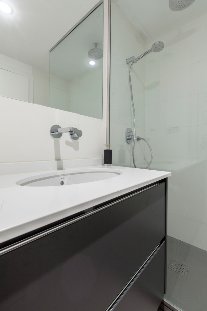Imagen de cuarto de baño contemporáneo de tamaño medio con armarios con paneles lisos, puertas de armario negras, ducha esquinera, paredes blancas, aseo y ducha y lavabo integrado