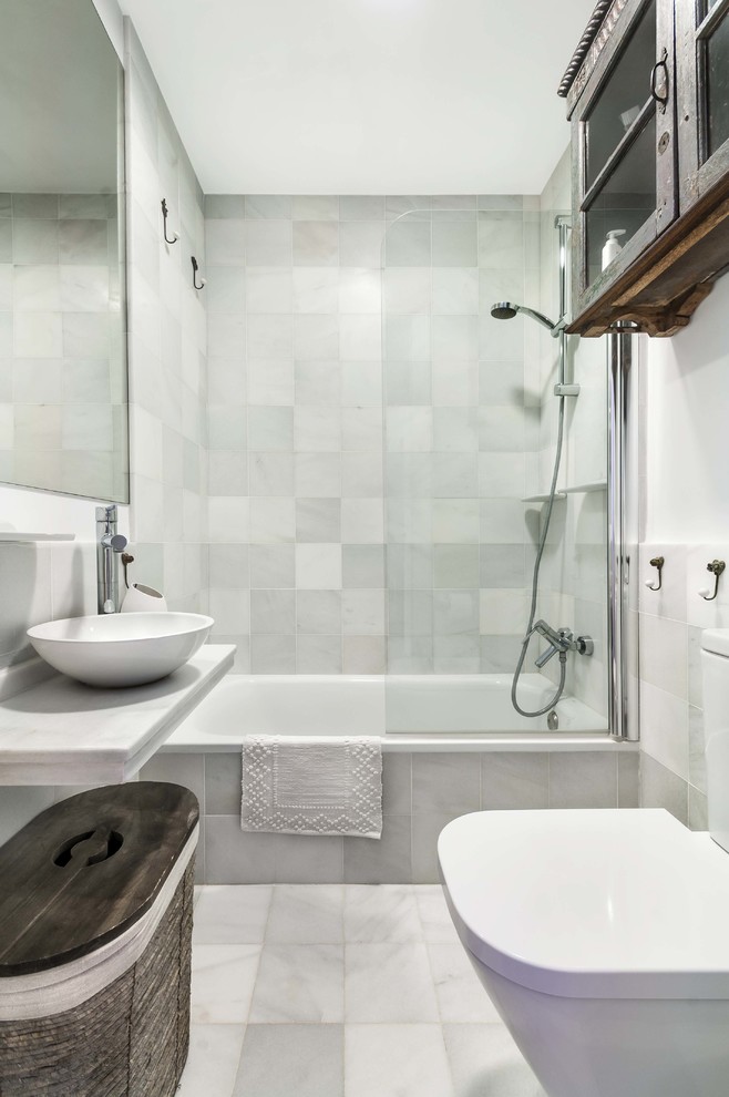 Imagen de cuarto de baño costero pequeño con bañera empotrada, combinación de ducha y bañera, sanitario de dos piezas, aseo y ducha y lavabo sobreencimera
