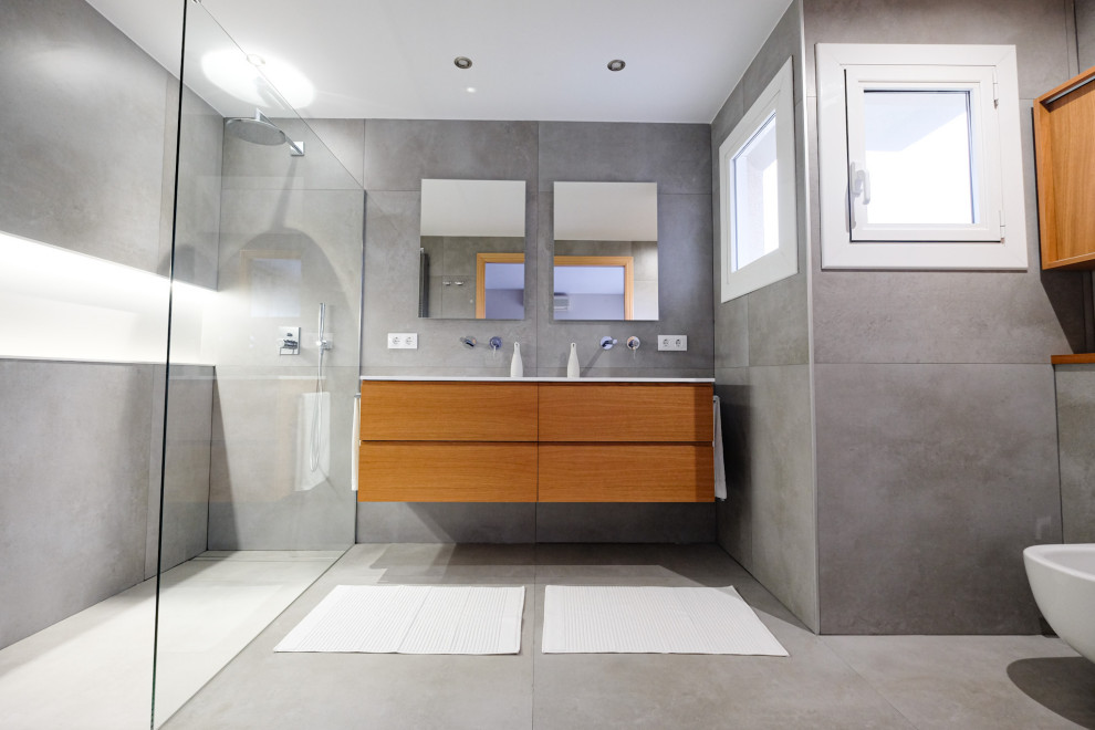 Inspiration for a large modern ensuite bathroom in Barcelona with open cabinets, grey cabinets, a built-in shower, a wall mounted toilet, grey tiles, porcelain tiles, grey walls, porcelain flooring, an integrated sink, grey floors, an open shower and white worktops.