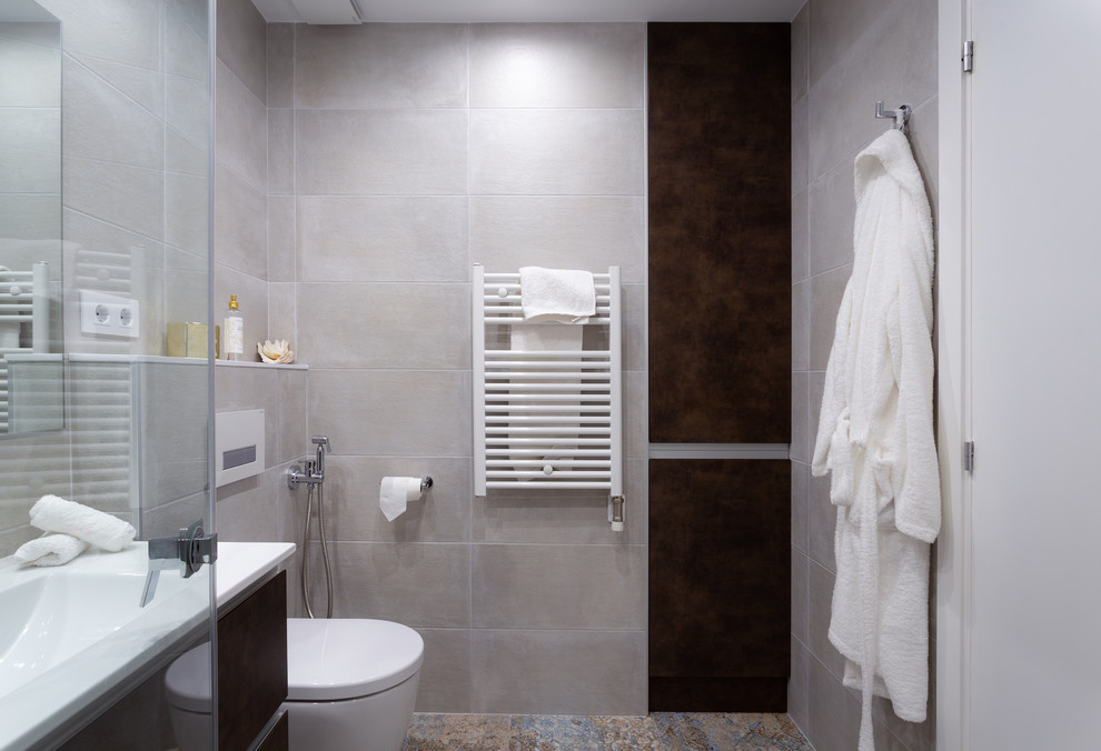 Inredning av ett modernt litet vit vitt en-suite badrum, med släta luckor, bruna skåp, en dusch i en alkov, en vägghängd toalettstol, vit kakel, keramikplattor, beige väggar, klinkergolv i keramik, ett avlångt handfat, flerfärgat golv och dusch med gångjärnsdörr