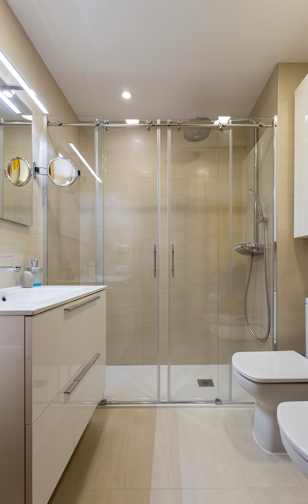 Ejemplo de cuarto de baño clásico renovado de tamaño medio con armarios con paneles lisos, puertas de armario blancas, ducha empotrada, sanitario de dos piezas, paredes beige, aseo y ducha y lavabo integrado