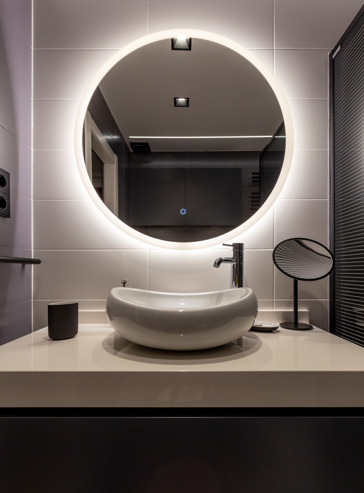 Diseño de cuarto de baño contemporáneo de tamaño medio con puertas de armario negras, ducha empotrada, sanitario de pared, baldosas y/o azulejos beige, paredes beige, lavabo sobreencimera y encimeras beige