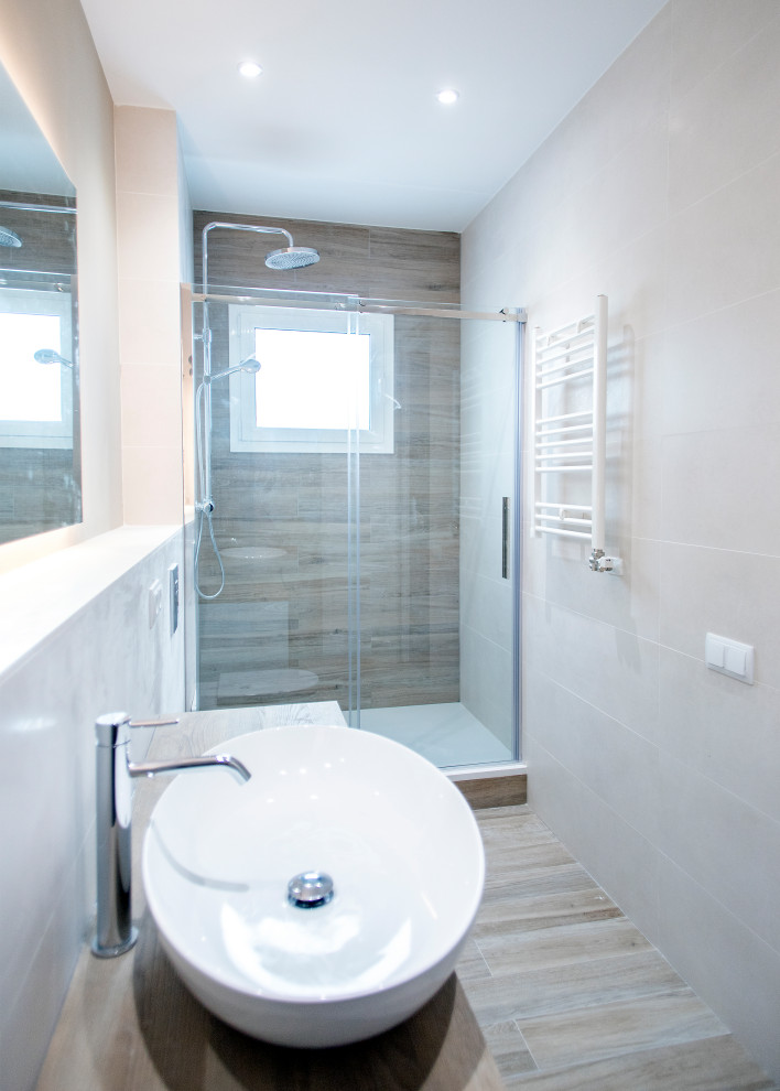 Ejemplo de cuarto de baño principal actual de tamaño medio con puertas de armario blancas, ducha a ras de suelo, sanitario de una pieza, baldosas y/o azulejos beige, baldosas y/o azulejos de cerámica, paredes beige, suelo de baldosas de cerámica, lavabo sobreencimera, encimera de madera, suelo marrón, ducha con puerta corredera y encimeras marrones