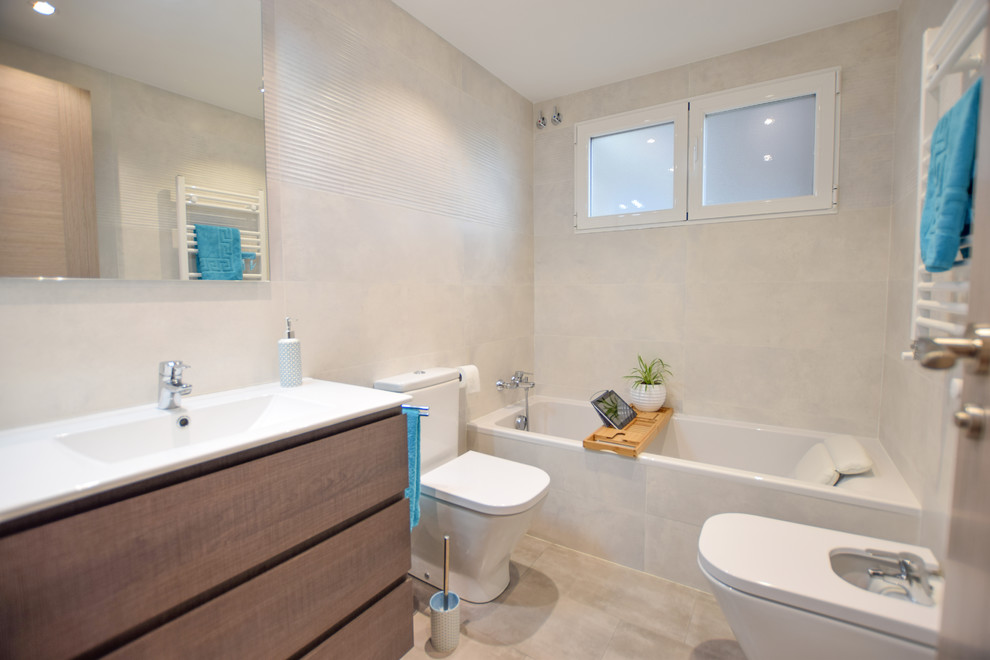 Réalisation d'une salle de bain principale nordique de taille moyenne avec une baignoire posée, WC séparés, un carrelage blanc, des carreaux de céramique, un mur blanc, un sol en carrelage de céramique, un lavabo intégré, un sol gris et un plan de toilette blanc.