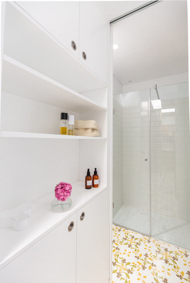 Idéer för mellanstora medelhavsstil vitt en-suite badrum, med en kantlös dusch, en vägghängd toalettstol, vit kakel, keramikplattor, vita väggar, klinkergolv i keramik, ett fristående handfat, bänkskiva i akrylsten, gult golv och dusch med gångjärnsdörr
