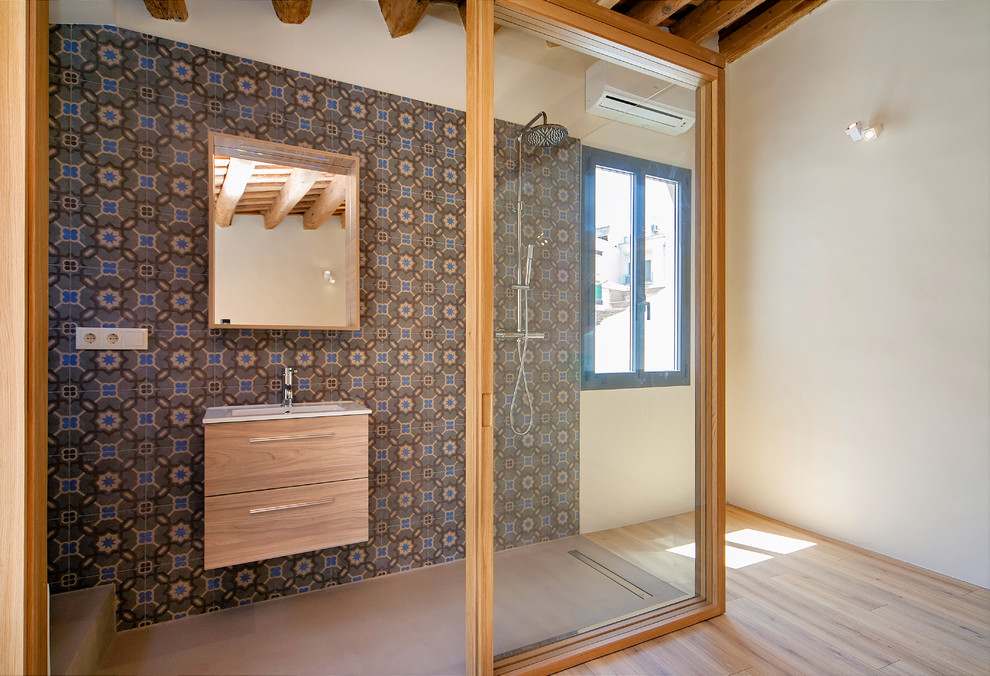 Esempio di una stanza da bagno mediterranea di medie dimensioni con ante lisce, ante in legno scuro, doccia aperta, pareti multicolore e lavabo integrato
