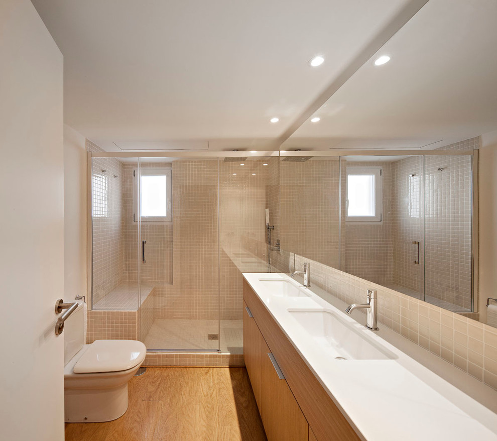 Imagen de cuarto de baño principal escandinavo de tamaño medio con armarios tipo mueble, puertas de armario de madera oscura, ducha empotrada, sanitario de dos piezas, suelo de madera en tonos medios y lavabo integrado