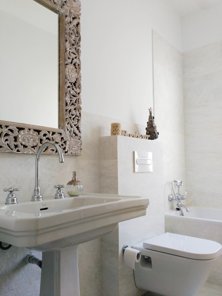 Imagen de cuarto de baño principal tradicional renovado de tamaño medio con bañera empotrada, combinación de ducha y bañera, sanitario de pared, paredes blancas y lavabo con pedestal