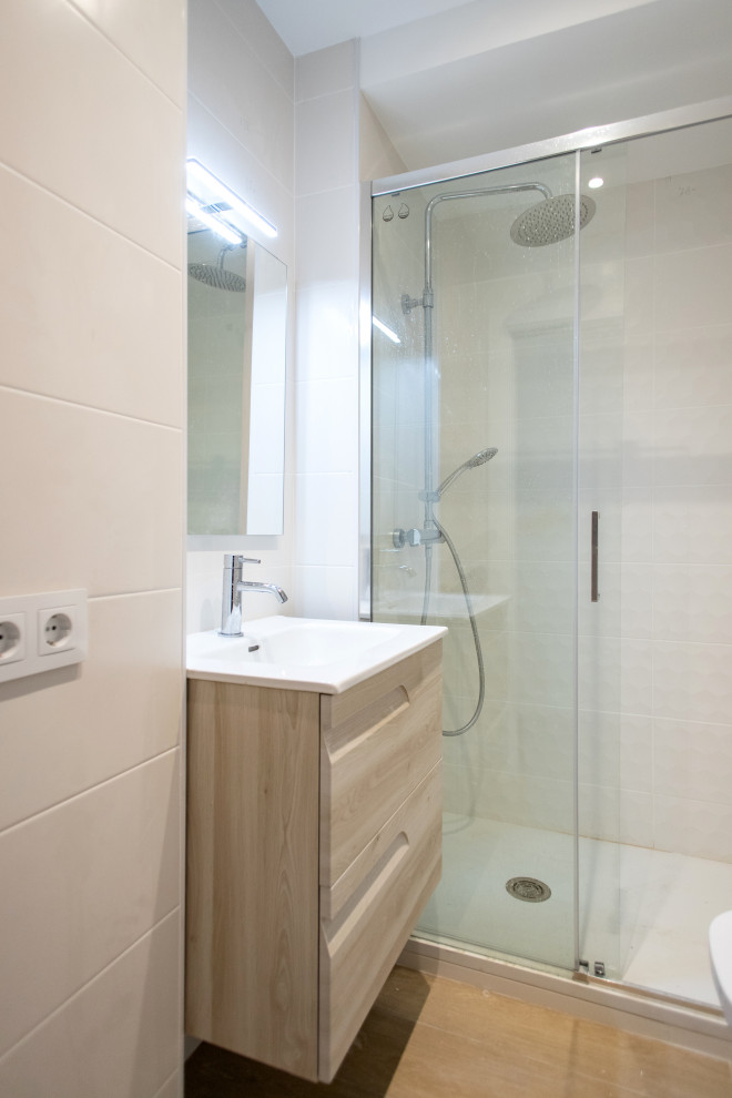 Foto på ett mellanstort funkis vit en-suite badrum, med skåp i mellenmörkt trä, en kantlös dusch, en toalettstol med separat cisternkåpa, vit kakel, klinkergolv i keramik, brunt golv och dusch med skjutdörr