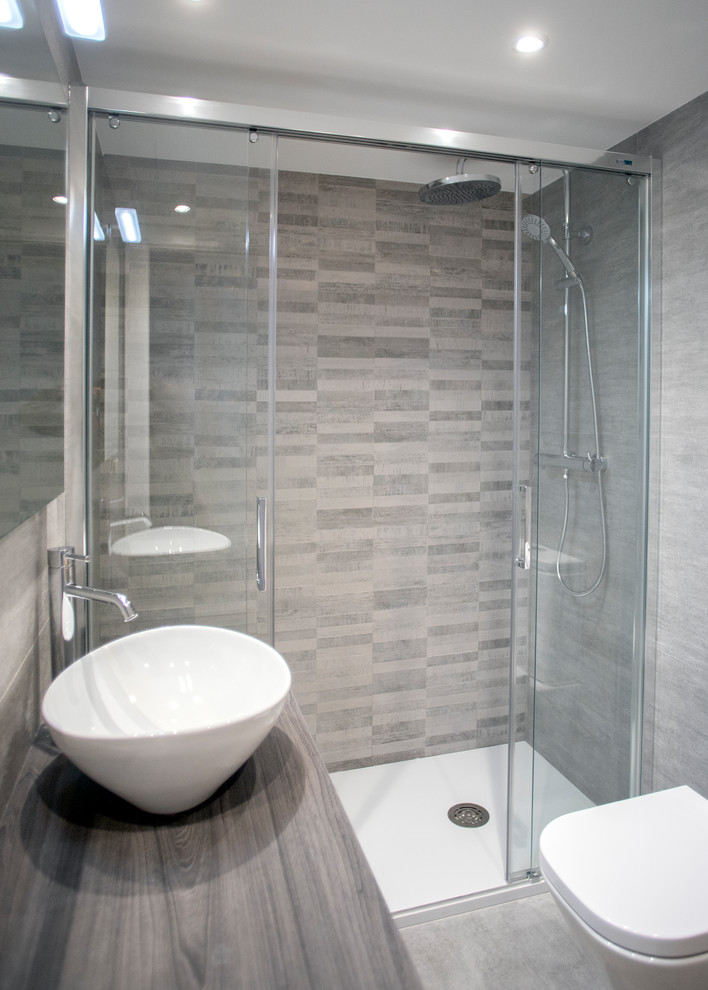 Exempel på ett mellanstort modernt brun brunt en-suite badrum, med en kantlös dusch, en toalettstol med hel cisternkåpa, beige kakel, klinkergolv i keramik, brunt golv och dusch med skjutdörr